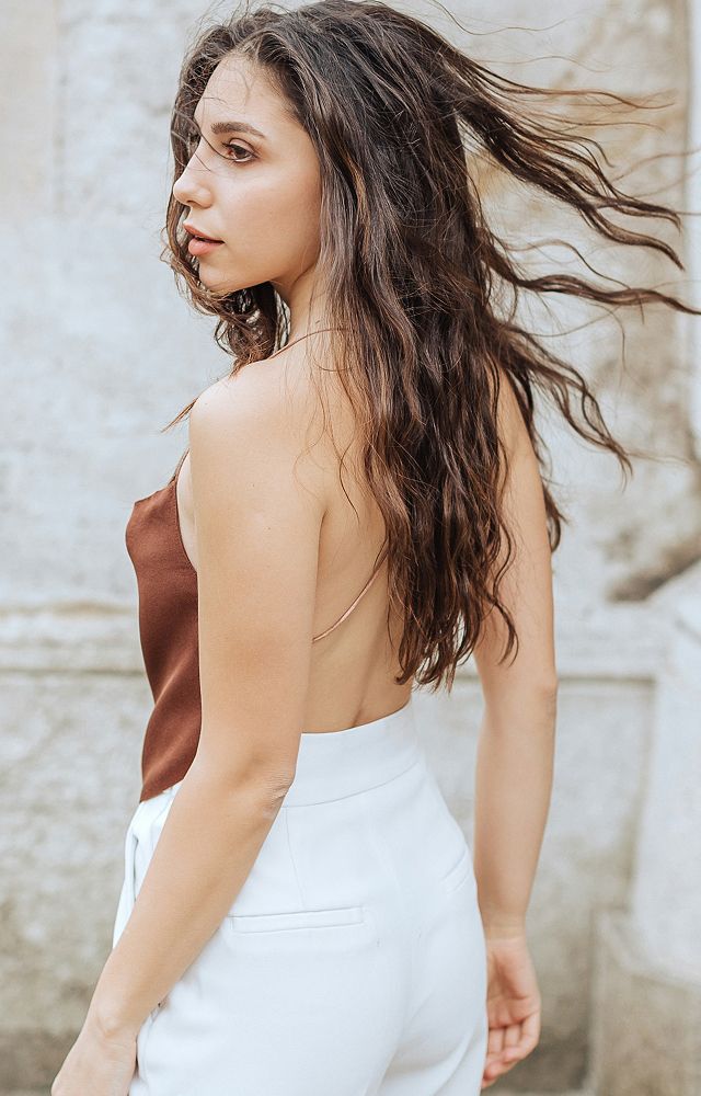 Young woman with curly hair in sunset light.