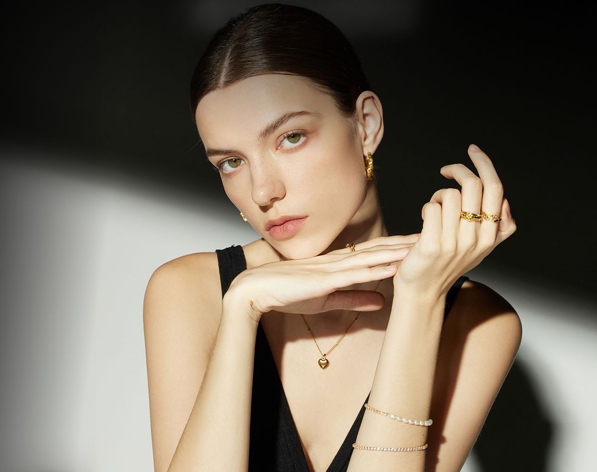 Model showcasing elegant jewelry in soft lighting.